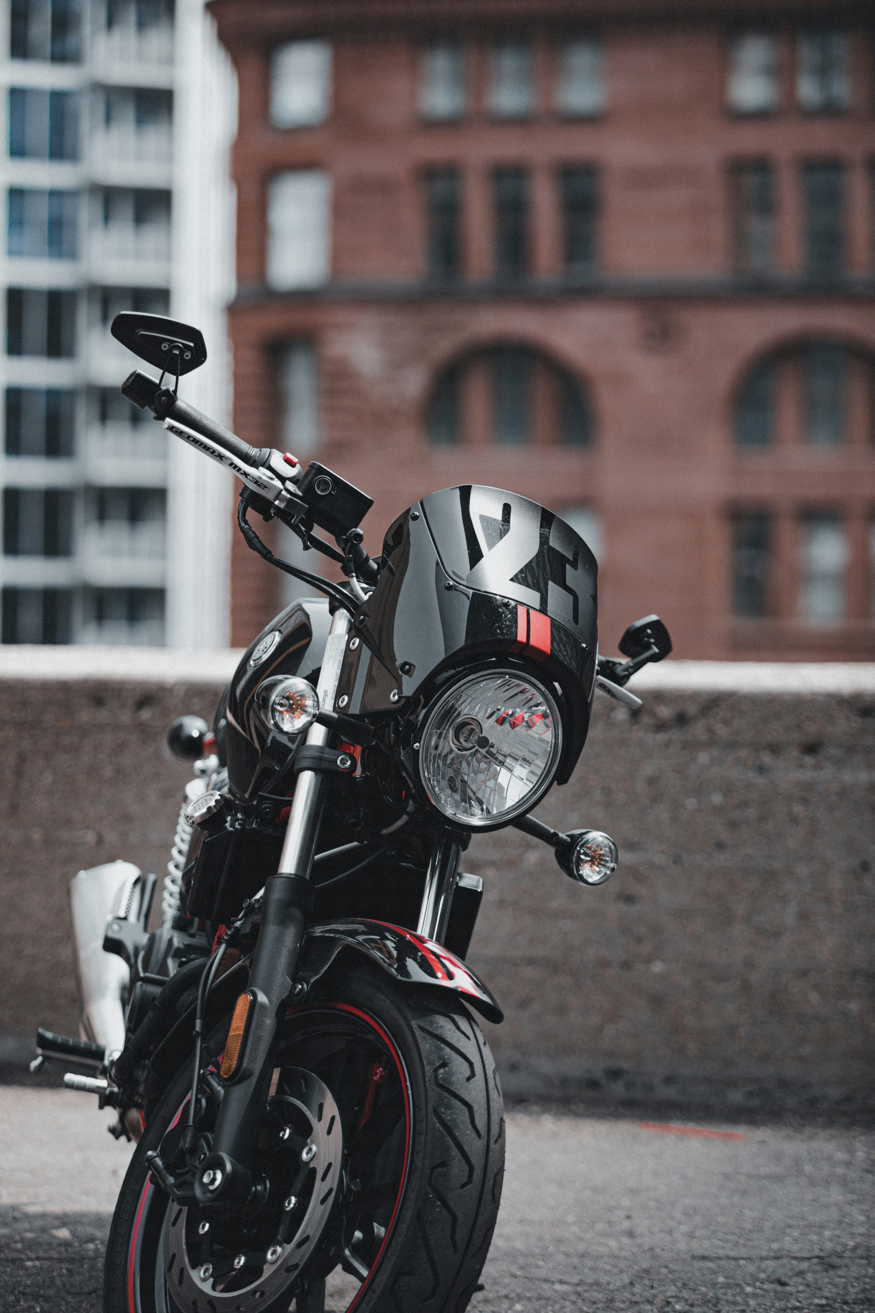 black motorcycle parked near brown building during daytime